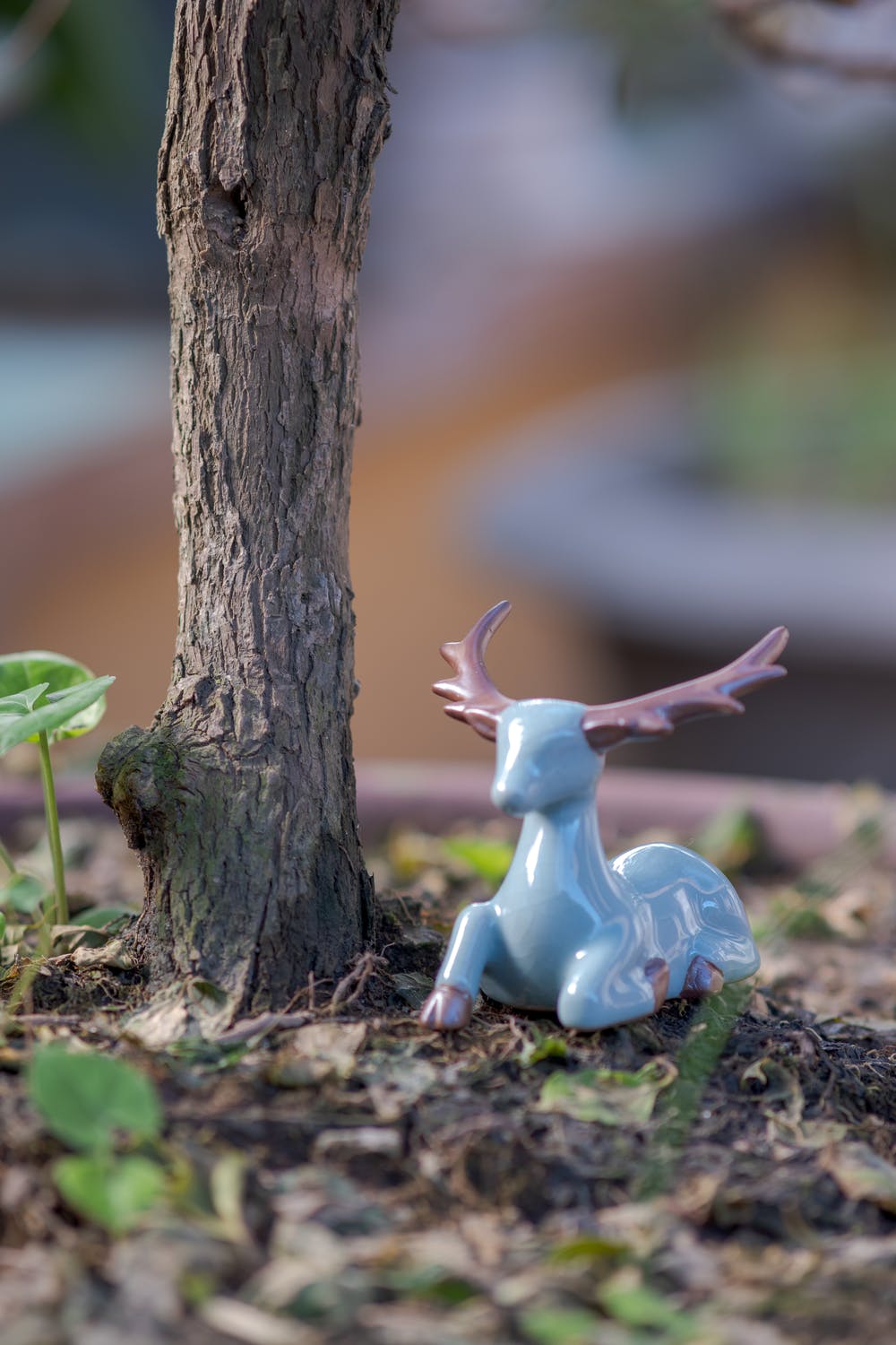 Eine Hirsch Figur im Garten neben Baum