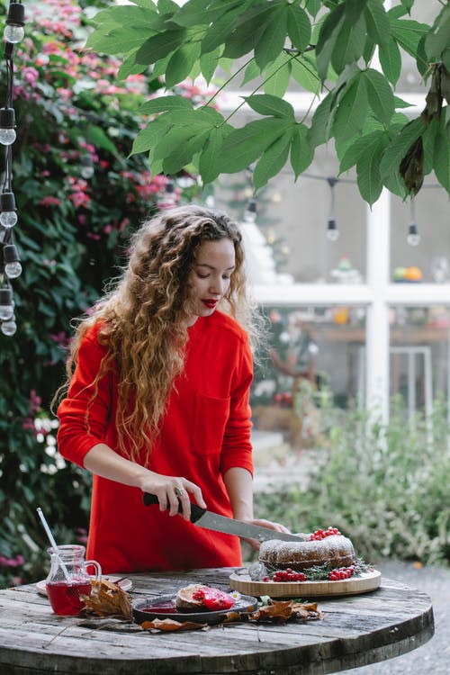 Frau bereitet Essen draußen in der Gartenküche zu